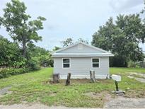 Charming home featuring a light gray exterior, classic white trim, and manicured yard at 702 Hillsboro St, Plant City, FL 33563