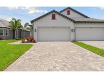 Two-car garage with paver driveway and landscaping at 17810 Cherished Loop, Bradenton, FL 34211