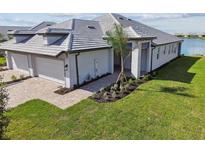 Two-car garage, tile roof, and landscaped lawn at 18039 Cherished Loop, Bradenton, FL 34211