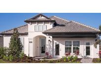Two-story house with gray tile roof, white exterior, and landscaping at 289 Vistera Blvd, Nokomis, FL 34275