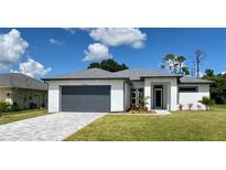 Modern one-story home with gray garage door and gray trim at 23466 Garrett Ave, Port Charlotte, FL 33954