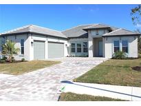 Beautiful single-story home featuring a paver driveway, two-car garage, and well-manicured landscaping at 13378 Amargo Ct, Venice, FL 34293