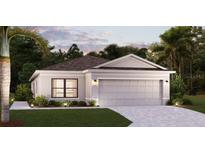 One-story home with gray garage door and landscaping at 16845 Fiesta Dr, Port Charlotte, FL 33953