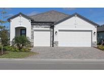 Charming single-story home featuring a two-car garage, stone accents, and a well-manicured front yard at 232 Vistera Blvd, North Venice, FL 34275