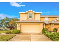 Tan two-story townhome with attached garage and landscaping at 11408 52Nd E Ct, Parrish, FL 34219