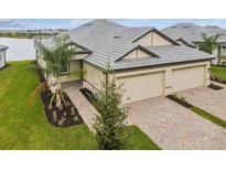 Two-car garage, double-wide driveway, and attractive landscaping at 18019 Cherished Loop, Bradenton, FL 34211