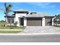 Beautiful one-story home with a three-car garage, well-manicured lawn, and elegant paved driveway at 2036 Bolsena St, Nokomis, FL 34275