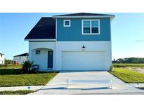 Charming two-story home featuring a two-car garage, blue siding, and well-maintained landscaping at 7950 Chandler Lake Ct, Hudson, FL 34667