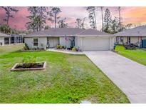 Charming single-story home featuring a well-manicured lawn and a two-car attached garage at 18149 Dillon Ave, Port Charlotte, FL 33954
