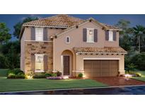 Charming two-story home with a clay tile roof, stone accents, and a two-car garage, beautifully landscaped at 17228 Savory Mist Cir, Lakewood Ranch, FL 34211