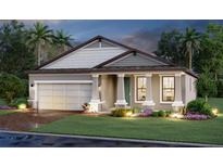 Inviting single-Gathering home featuring a two-car garage, covered entryway, and beautifully landscaped front yard at 17220 Savory Mist Cir, Bradenton, FL 34211