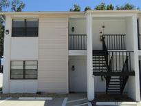 Two-story condo complex featuring neutral toned siding and an entrance area with stairs to the second level at 3102 W Horatio St # 21, Tampa, FL 33609