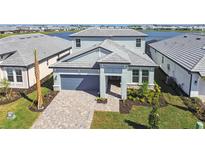 Beautiful two-story home with gray accents, well-manicured landscaping, and a paver driveway at 17245 Savory Mist Cir, Bradenton, FL 34211