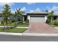 Beautiful single-story home with a brick driveway, well-maintained landscaping, and a two-car garage at 2735 Lavandula Ct, North Port, FL 34289