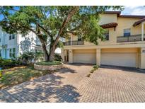 Stunning exterior view of home with mature landscaping and a multi-car garage and brick paved driveway at 4604 W Fig St # 1, Tampa, FL 33609