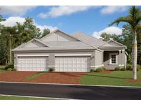Beautiful new construction featuring a three-car garage, lush landscaping, and brick driveway at 18068 Cherished Loop, Bradenton, FL 34211