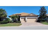Charming single-story home with a tile roof, brick paver driveway and well-manicured landscaping at 227 Heritage Preserve Run, Bradenton, FL 34212