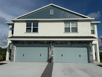 Two-story townhome featuring stone accents and two-car garages at 13978 Emerald Fields Dr, Hudson, FL 34667