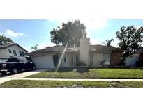 Exterior view of house featuring a manicured lawn, driveway, and attached garage at 5552 Pentail Cir, Tampa, FL 33625