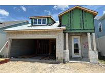 Unfinished house exterior showing open garage and front door entry under blue skies at 7963 Chandler Lake Ct, Hudson, FL 34667