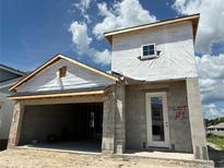 New construction home featuring block construction, modern door, and an attached garage at 7979 Chandler Lake Ct, Hudson, FL 34667