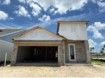 An unfinished single Gathering home showing exterior elevation of the construction with an open garage at 7979 Chandler Lake Ct, Hudson, FL 34667