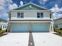 New two-story townhome with two-car garage and manicured landscaping at 13964 Emerald Fields Dr, Hudson, FL 34667