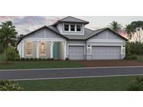 Charming single-story home featuring a two-car garage, a teal-colored front door, and craftsman-style details at 16811 Sweetwater Village Dr, Lakewood Ranch, FL 34211