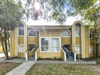 Front view of a charming yellow duplex with lush landscaping at 304 34Th Avenue E Dr # 304, Bradenton, FL 34208