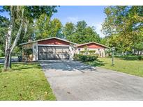 Ranch-style home with attached garage and a long driveway at 12444 Coronado Dr, Spring Hill, FL 34609