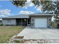 Ranch-style home with a two-car garage and well-maintained landscaping at 40610 State Road 64 E, Myakka City, FL 34251