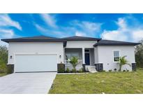 Charming single-story home with a two-car garage, landscaped front yard and covered front entry at 14112 Monserrate Ln, Port Charlotte, FL 33981