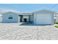 Newly renovated house with a light blue exterior, two-car garage, and paved driveway at 4229 Floramar Ter, New Port Richey, FL 34652