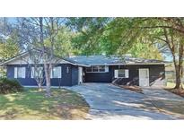 Dark-painted house with a driveway, surrounded by lush green trees at 406 E Young St, Plant City, FL 33563