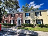 Brick front of two-story building with manicured landscaping at 13824 Orange Sunset Dr # 202, Tampa, FL 33618
