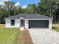 New single-Gathering home with gray garage door at 13435 Kaplan Ter, Port Charlotte, FL 33981