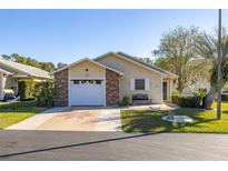 Charming single-story home featuring a brick-accented garage and well-maintained landscaping at 5846 Greenbriar Ct, Zephyrhills, FL 33542