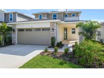 Inviting two-story home with stone accents, manicured lawn, and an attached two-car garage at 5936 Jensen View Ave, Apollo Beach, FL 33572