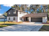 Charming two-story home with a brick and siding exterior and a spacious two-car garage at 407 Belvedere Oval, Temple Terrace, FL 33617