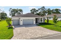 Beautiful single-story home with a three-car garage and a well-manicured lawn at 9071 Players Dr, Weeki Wachee, FL 34613