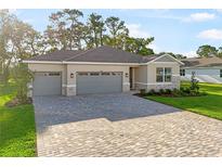 Charming single-story home boasts a three-car garage and a beautifully paved driveway at 9109 Players Dr, Weeki Wachee, FL 34613