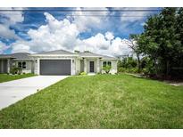 Charming single-story home boasts a well-manicured lawn and a stylish gray garage door at 183 Wright Drive, Rotonda West, FL 33947