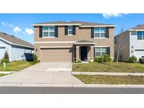 Charming two-story home with a well-maintained lawn, two car garage, and appealing curb appeal at 7522 Rosewood Garden Loop, Tampa, FL 33637