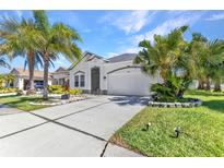 Charming single-story home boasting a well-manicured lawn, lush palm trees, and a welcoming two-car garage at 2640 Suncoast Lakes Blvd, Punta Gorda, FL 33980