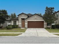Charming single-story home featuring a well-maintained lawn, two-car garage, and classic architectural details at 675 Hartford Heights St, Spring Hill, FL 34609