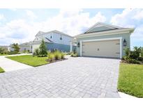 Charming single-Gathering home featuring a two-car garage, a stone driveway, and a well-manicured lawn at 14552 Skipping Stone Loop, Parrish, FL 34219
