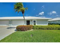 Charming single-story home with a well-manicured lawn and a swaying palm tree in a sunny, cheerful setting at 6522 11Th W Ave, Bradenton, FL 34209
