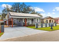 Charming single-story home with grey siding, white trim, solar panels, and a cozy front porch at 2912 W Frierson W Ave, Tampa, FL 33614