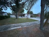 Charming single-story home featuring a front porch and an attached one-car garage with lush lawn at 1912 W Clinton St, Tampa, FL 33604