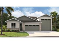 Attractive single-story home featuring a well-manicured lawn, stone accents, and a two-car garage at 9177 Players Dr, Weeki Wachee, FL 34613